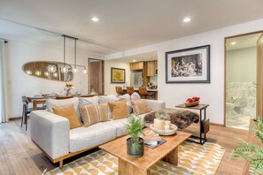 Un salon moderne comprenant un canapé, une table basse et un coin repas avec des chaises et une table.