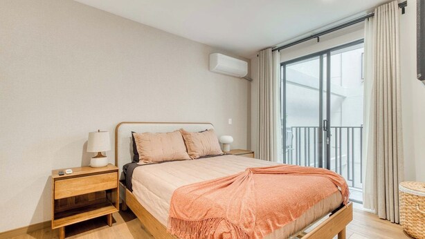 A bedroom with a bed, nightstand, and a window with curtains. - Chic 2BR in Condesa  Rooftop Pool Fast WiFi (Ciudad de México)