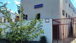 Egy épület, amelyen az „ADHARA HOTEL” feliratú tábla látható, és amelyet egy kapuval elzárt bejárat vezet.