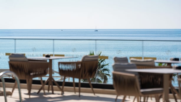 A seaside restaurant with outdoor seating overlooking the ocean. - Hotel Invictus (Becici)