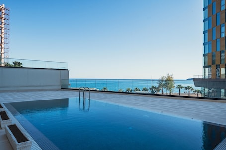 Una piscina al aire libre de temporada, sombrillas