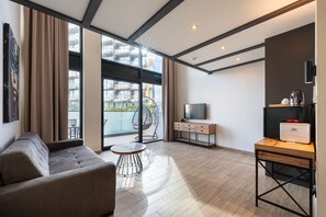 Alloggio Deluxe su due livelli, 1 letto queen con divano letto, balcone, vista piscina | Area soggiorno | Smart TV 43 pollici con canali via cavo, libri, stampante