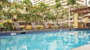 A swimming pool with lounge chairs and palm trees. - Honu Hideaway Studio at Royal Garden | Lanai Oasis (Honolulu)