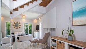 Een moderne woonkamer met een bank, fauteuil en een houten console met manden.