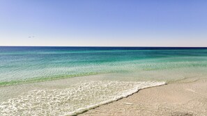 A beach with clear turquoise water and a sandy shore.