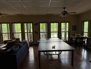 Une pièce spacieuse avec une grande table, un canapé et un ventilateur de plafond.