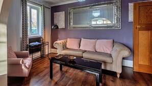 Een woonkamer met een bank, een salontafel en een kroonluchter.