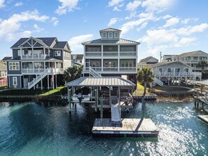 A waterfront property with multiple buildings, a dock, and a covered area.