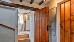 A wooden staircase leading to a room with a window and a map on the wall. - Whitley (Molland)