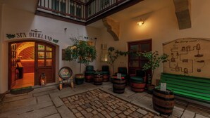 Un interior acogedor con un letrero que dice "SPA BEERLAND", barriles de madera y un banco verde.