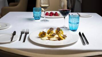 A dining table set with plates, cutlery, and glasses.
