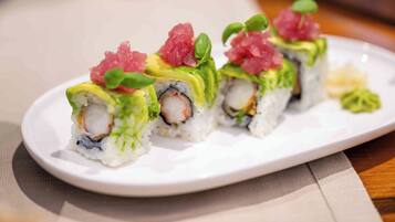 A plate of sushi with avocado and fish toppings.