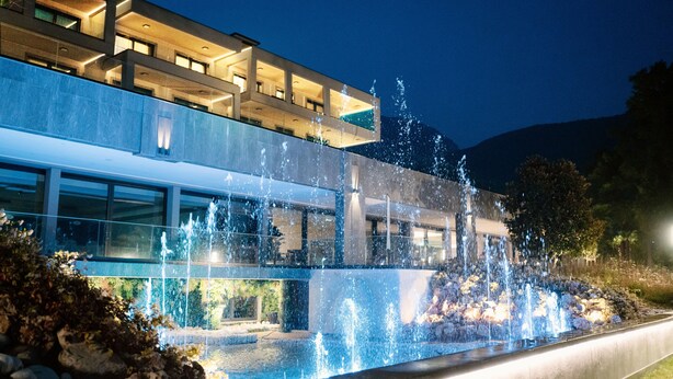 A modern building with a water feature in front. - Swiss Diamond Boutique Hotel La Romantica (Melide)