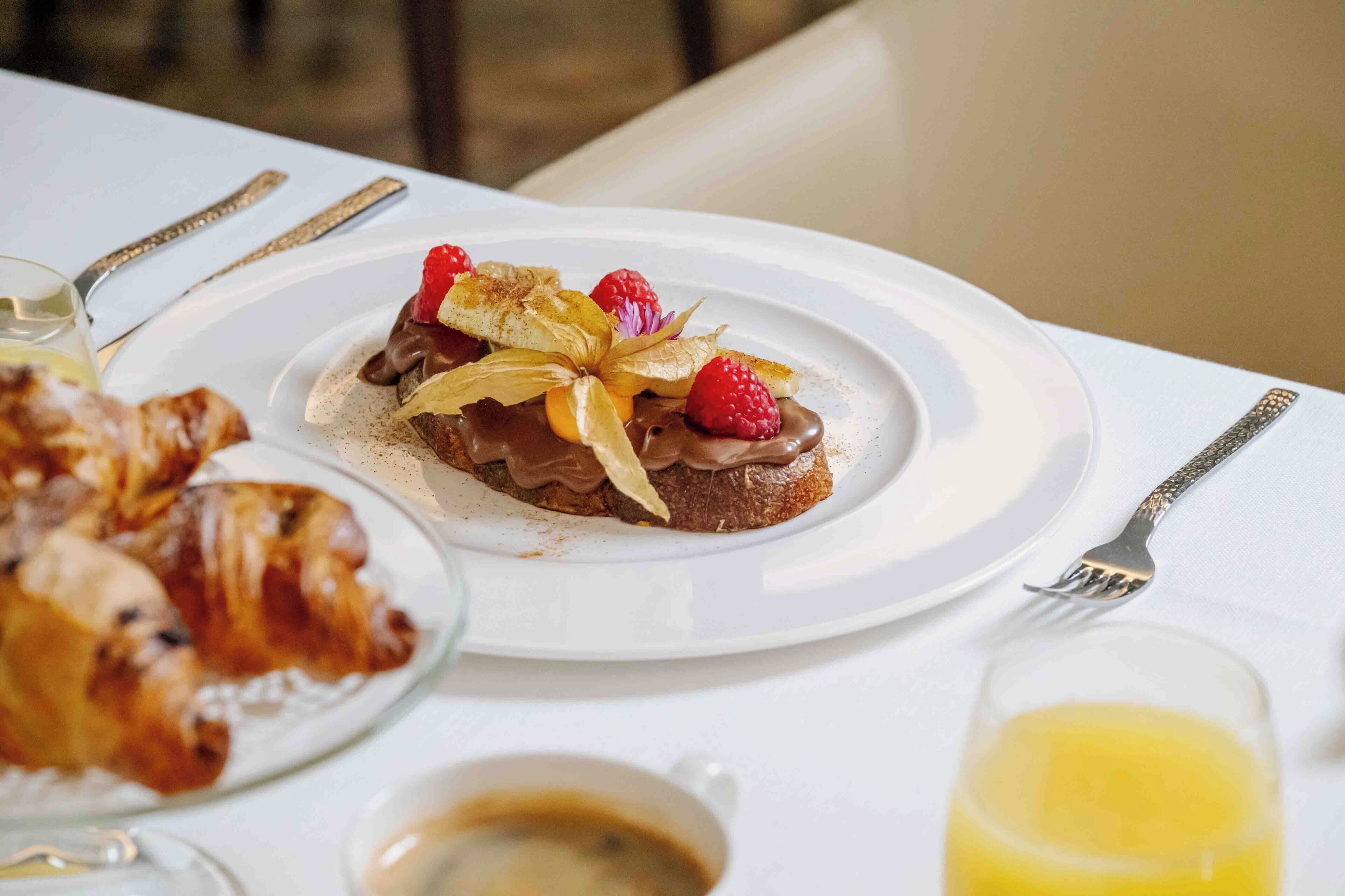 A breakfast setting with a plate of food, a glass of orange juice, and a cup of coffee.