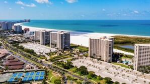 Ein Küstenhotel mit mehreren Hochhäusern, einem Strand und einem Parkplatz mit Sportplätzen.