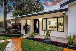 A modern house with a well-maintained garden, a clear pathway, and a large window. - Tropical Getaway | Heated Pool & Patio Retreat (Fort Lauderdale)