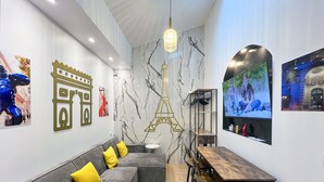 Un intérieur moderne avec un canapé, une table en bois et un écran de télévision diffusant une scène.