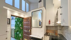 Une cuisine moderne dotée d’un plan de travail en marbre, d’un évier encastré et d’un grand miroir placé au-dessus de l’évier.