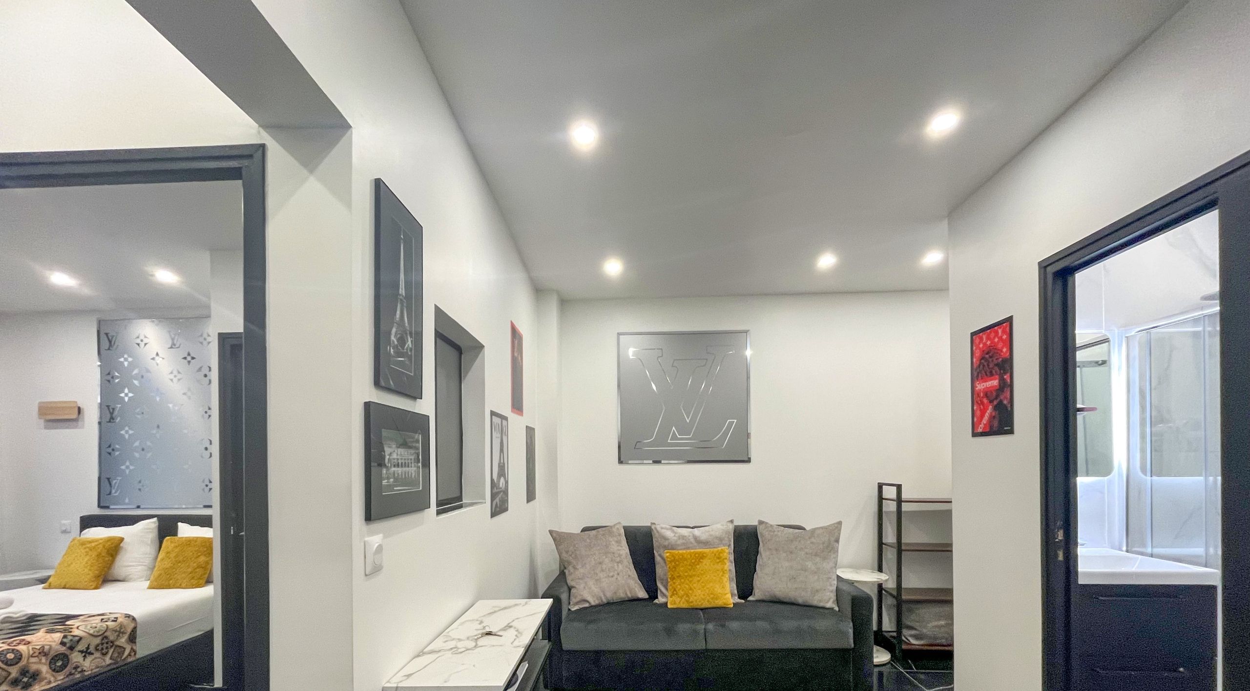 A modern bedroom with a bed, a sofa, and a small table.