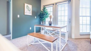 A room with a wooden bench, a white table, a potted plant, and a framed picture on the wall. - Boulevard Stays Peaceful 1BR King Suite Pool, Parking Gym 02 (Austin)