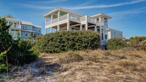 A large, two-story beachfront house with a balcony and a covered porch. - Incredible ocean views from Sand Castle on Bald Head Island (Bald Head Island)