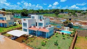 A modern residential complex with multiple two-story houses, a swimming pool, and well-maintained lawns. - PV 102 (Kibaoni)