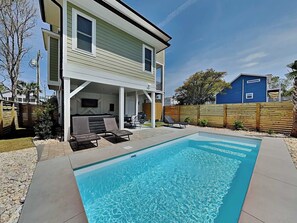 Une maison à deux étages dotée d’un patio couvert et d’une piscine.