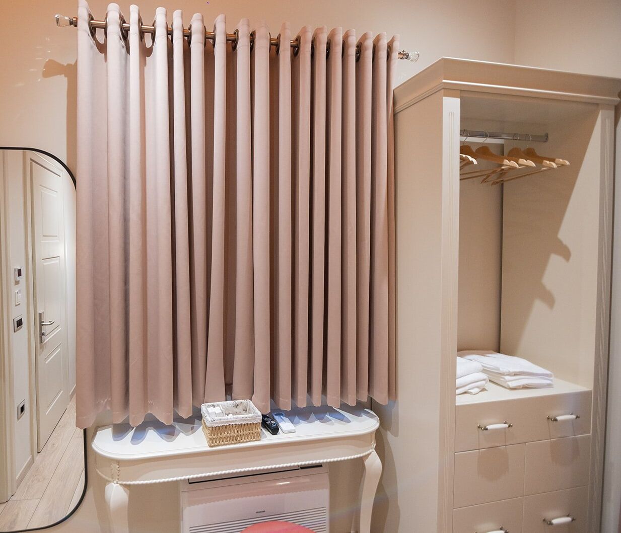 A bathroom with a white cabinet, a towel rack, and a shower curtain.