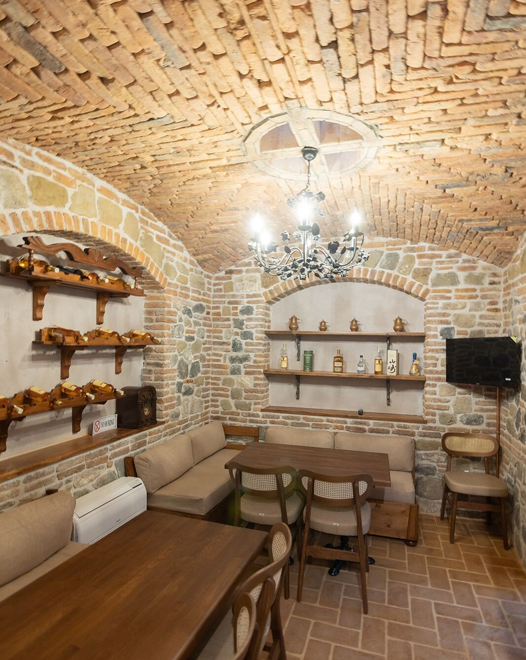 Um interior acolhedor com paredes de pedra, móveis de madeira e lareira.