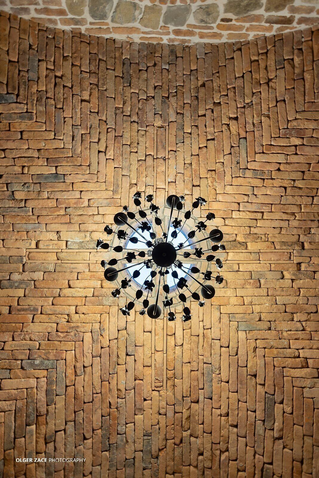 A brick wall with a circular pattern of black and white decorative elements.