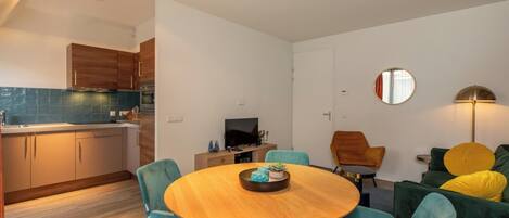 A modern living space with a kitchen, dining area, and seating area.