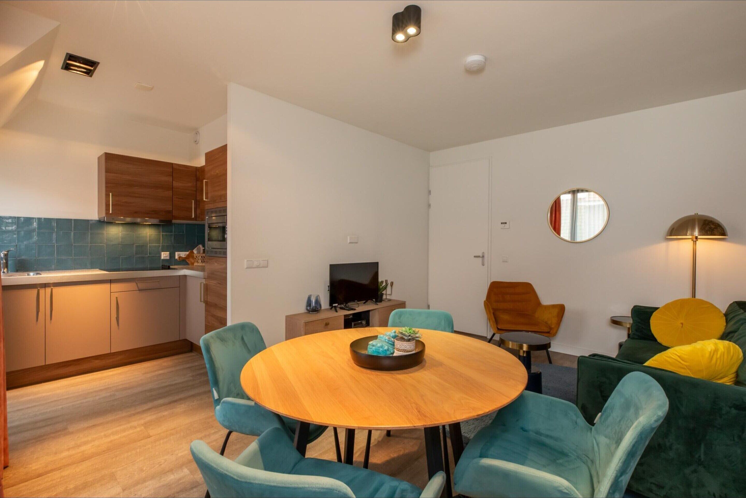 Een moderne woonruimte met keuken, eetgedeelte en zithoek.
