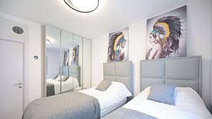 A hotel room with two beds, a large mirror, and artwork on the wall. - 3BR Beach&City Vibes in Bugrashov by HolyGuest (Tel Aviv-Yafo)