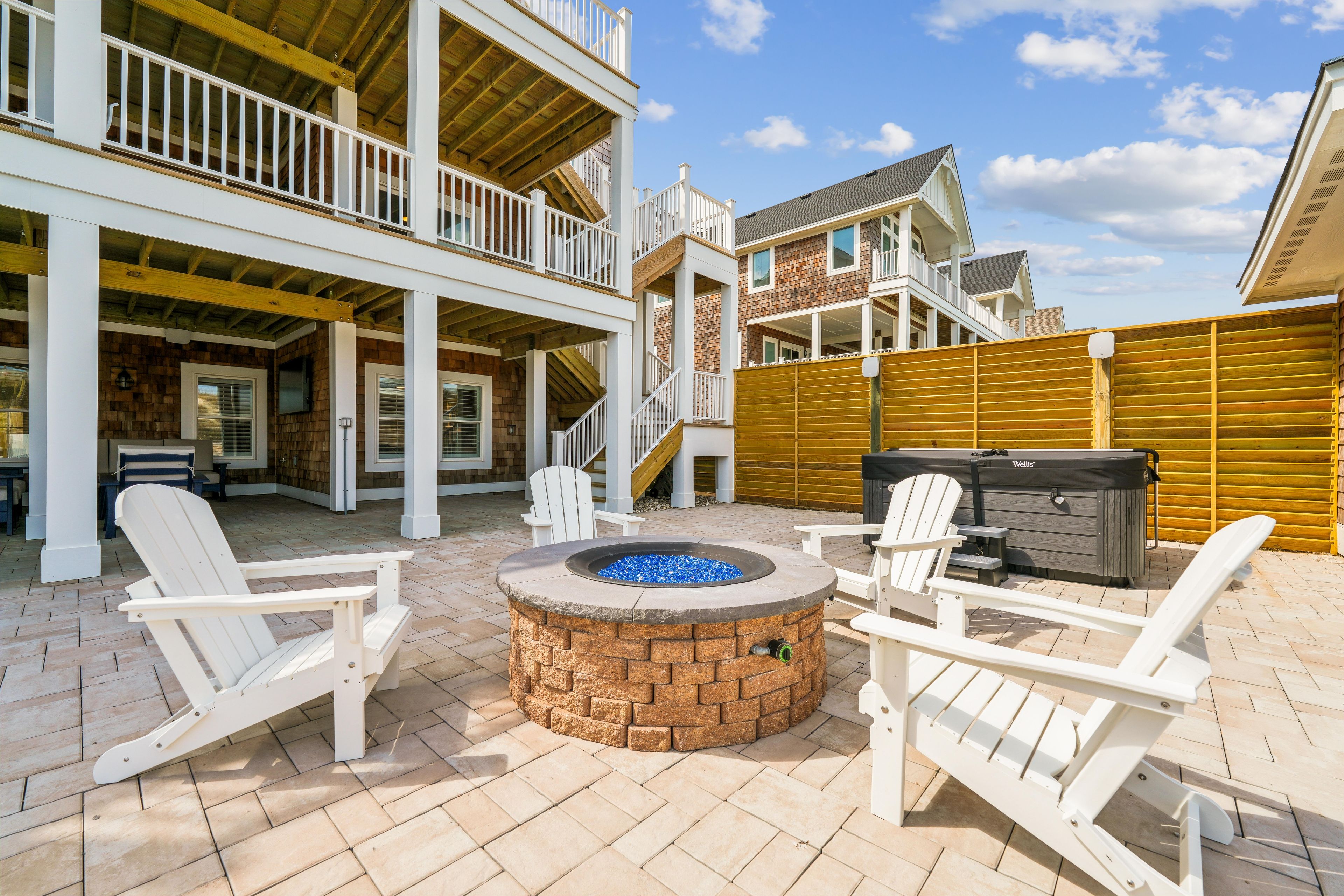 A patio area with a fire pit, outdoor seating, and a covered deck.