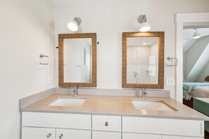 Une salle de bain avec deux lavabos, un miroir et un porte-serviettes.