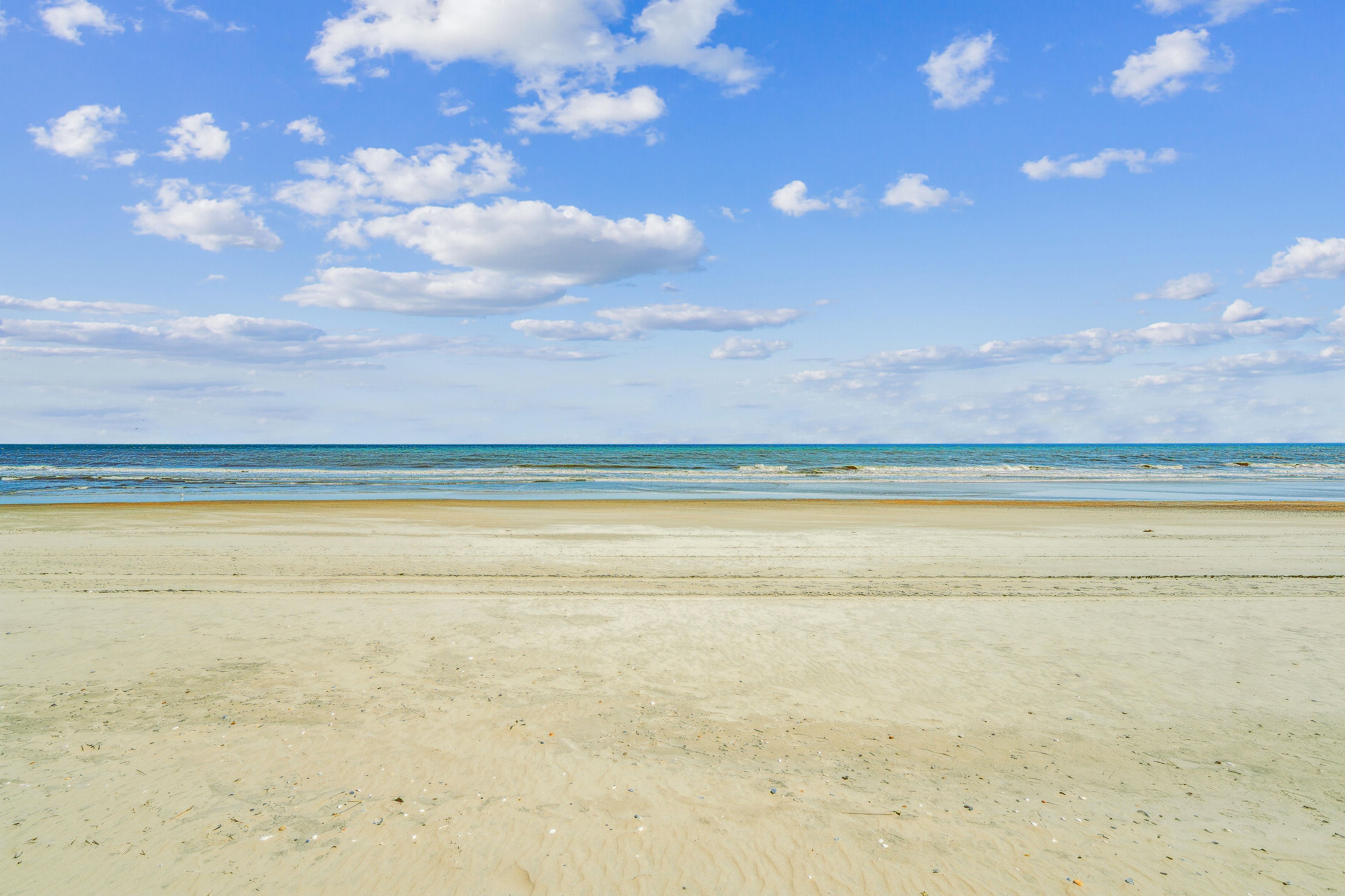 A beach with a clear sky and ocean waves.