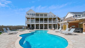 A two-story house with a swimming pool, outdoor furniture, and a barbecue area. - Owens -- Brand New 12 BR Luxury Oceanfront (Corolla)