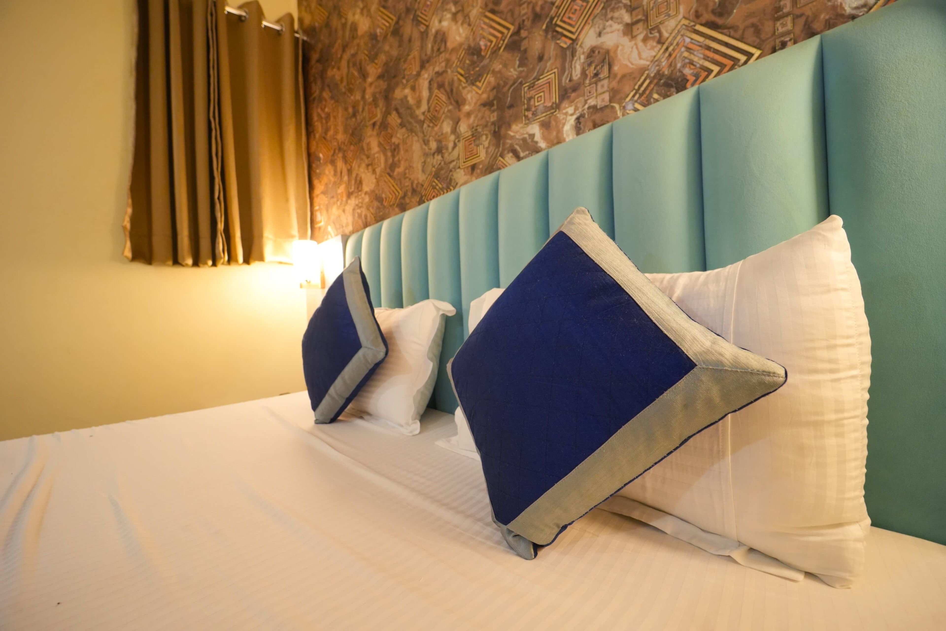 Ein Hotelzimmer mit einem Bett, Kissen und einem Kopfteil.