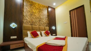 A hotel room with a large bed, wooden paneling, and a patterned wall. - Kashi Pilgrim Stay (Varanasi)