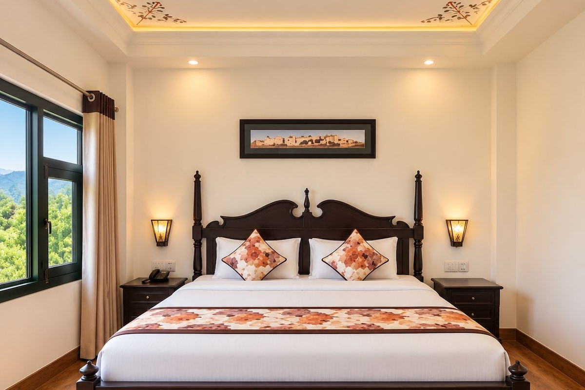 A hotel room with a large bed, two bedside tables with lamps, a framed picture on the wall, and a window with curtains.