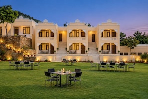 A multi-story building with a courtyard, outdoor seating, and a staircase leading to the upper floors. - Hill Garden Resort – Near Fateh Sagar, Udaipur (Udaipur)
