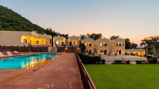 Un resort con piscina, varias villas para huéspedes y un césped bien cuidado.
