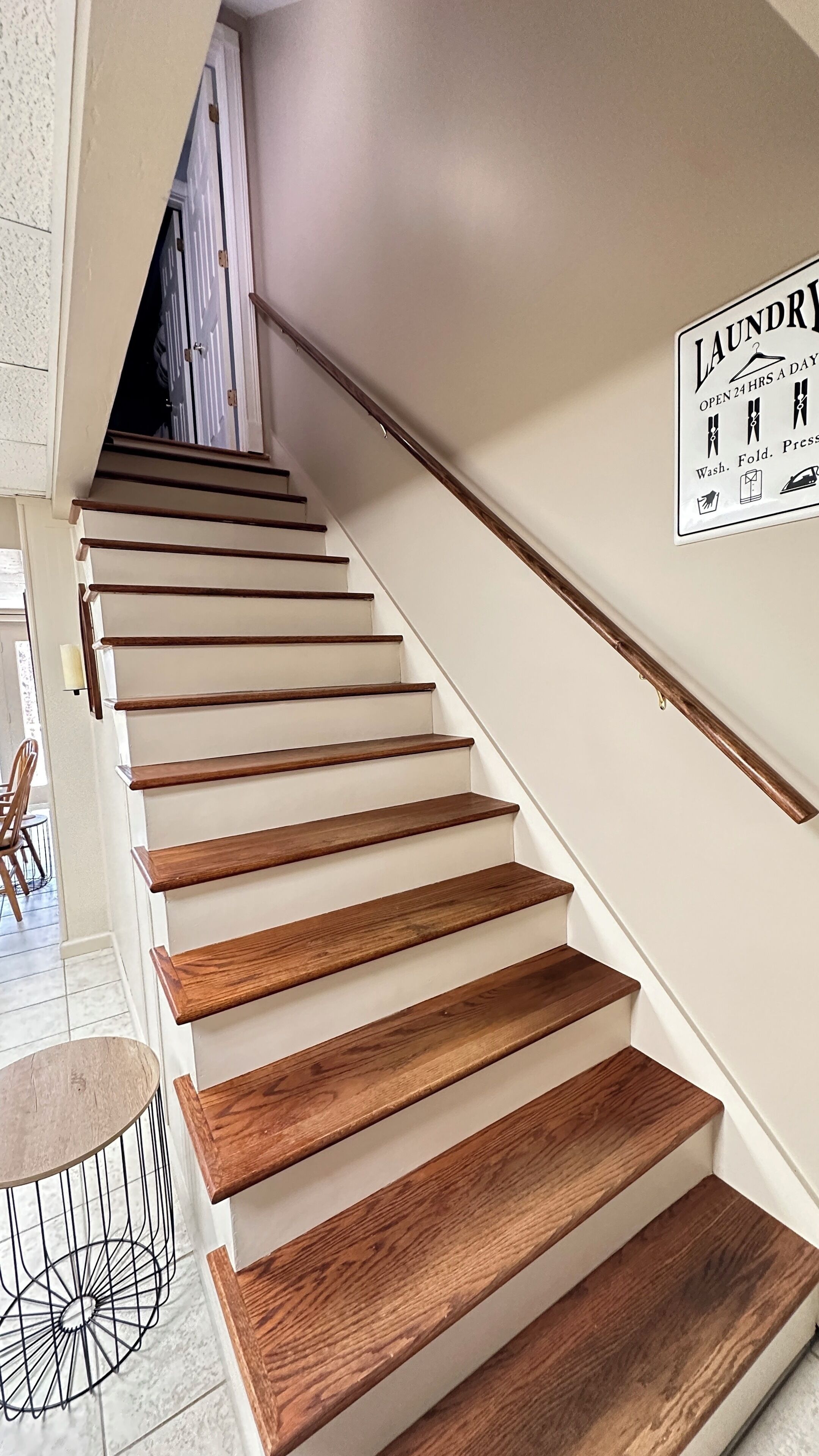 Eine Treppe mit Holzdielen und einem Schild, das einen rund um die Uhr geöffneten Waschservice anzeigt.