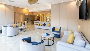 Eine moderne Hotelhalle mit Sofas, Sesseln und einem Couchtisch.