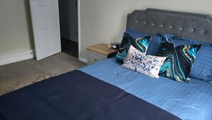 A bedroom with a bed, a nightstand, and a door. - 1BR Sleeps6 Elizabethline Ws98 (London)