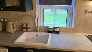 A kitchen with a white sink, a kettle, and two soap dispensers labeled "HAND SOAP" and "DISH SOAP". - 1BR Sleeps6 Elizabethline Ws98 (London)