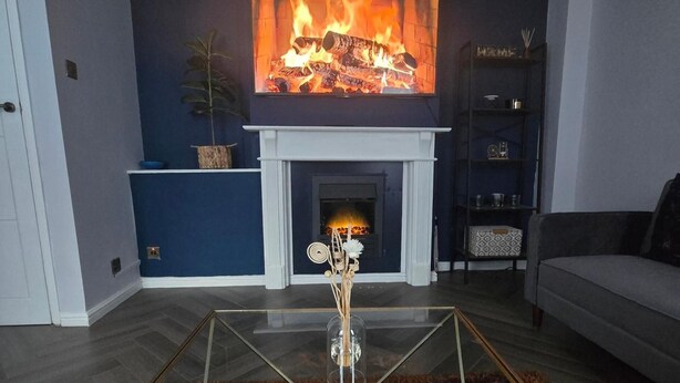 A living room with a fireplace, a sofa, and a glass coffee table. - 1BR Sleeps6 Elizabethline Ws98 (London)
