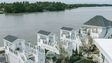 Propiedad frente al agua con varios edificios blancos, un río y una costa lejana.