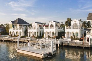 A waterfront property with multiple buildings, a dock, and a clear sky. - Prima Amphawa (Mueang Samut Songkhram)