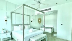 A bedroom with a four-poster bed, a bedside table, a bench, and a mirror. - Prima Amphawa (Mueang Samut Songkhram)